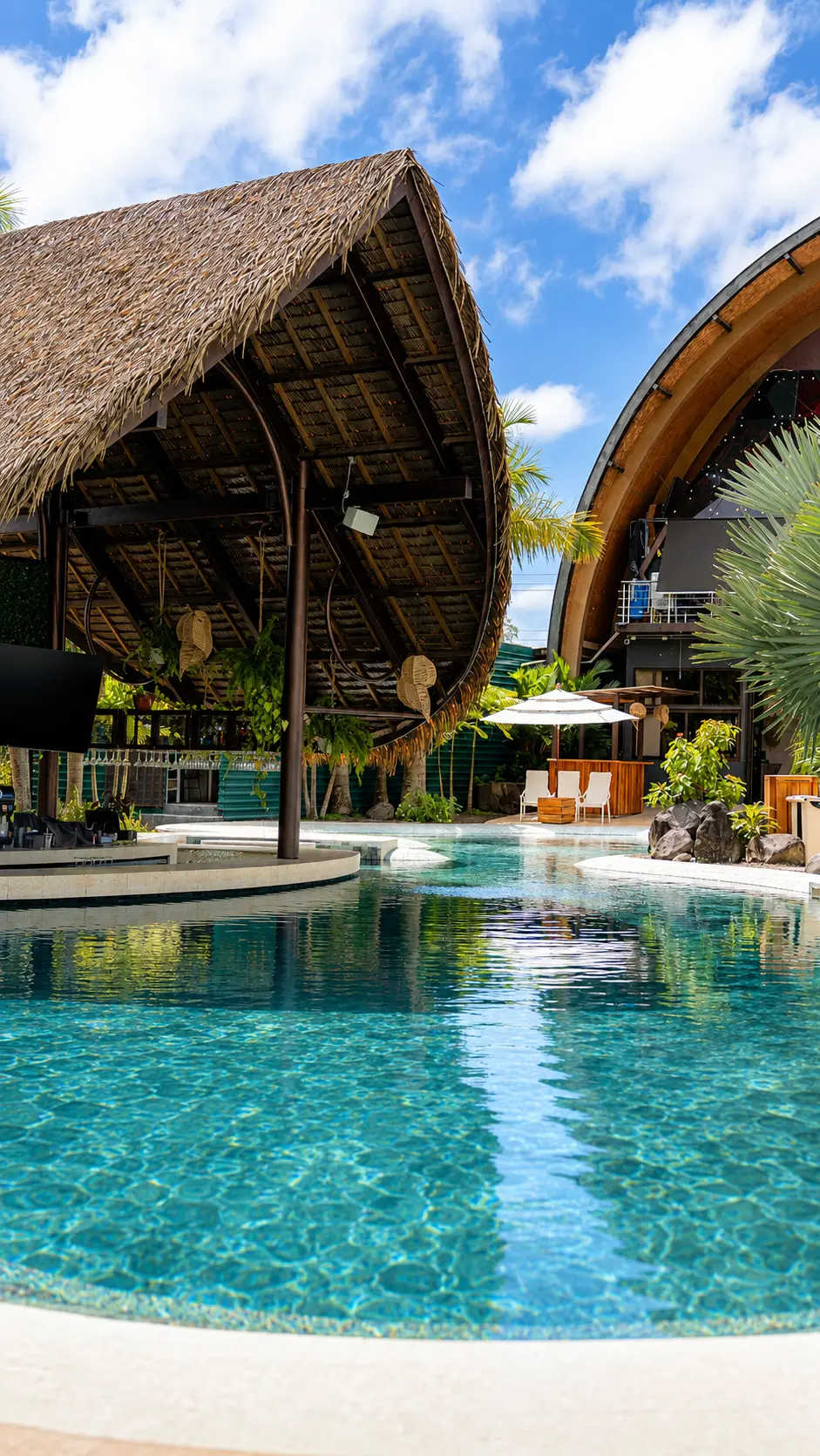 Turquoise pool beside the thatched pool bar